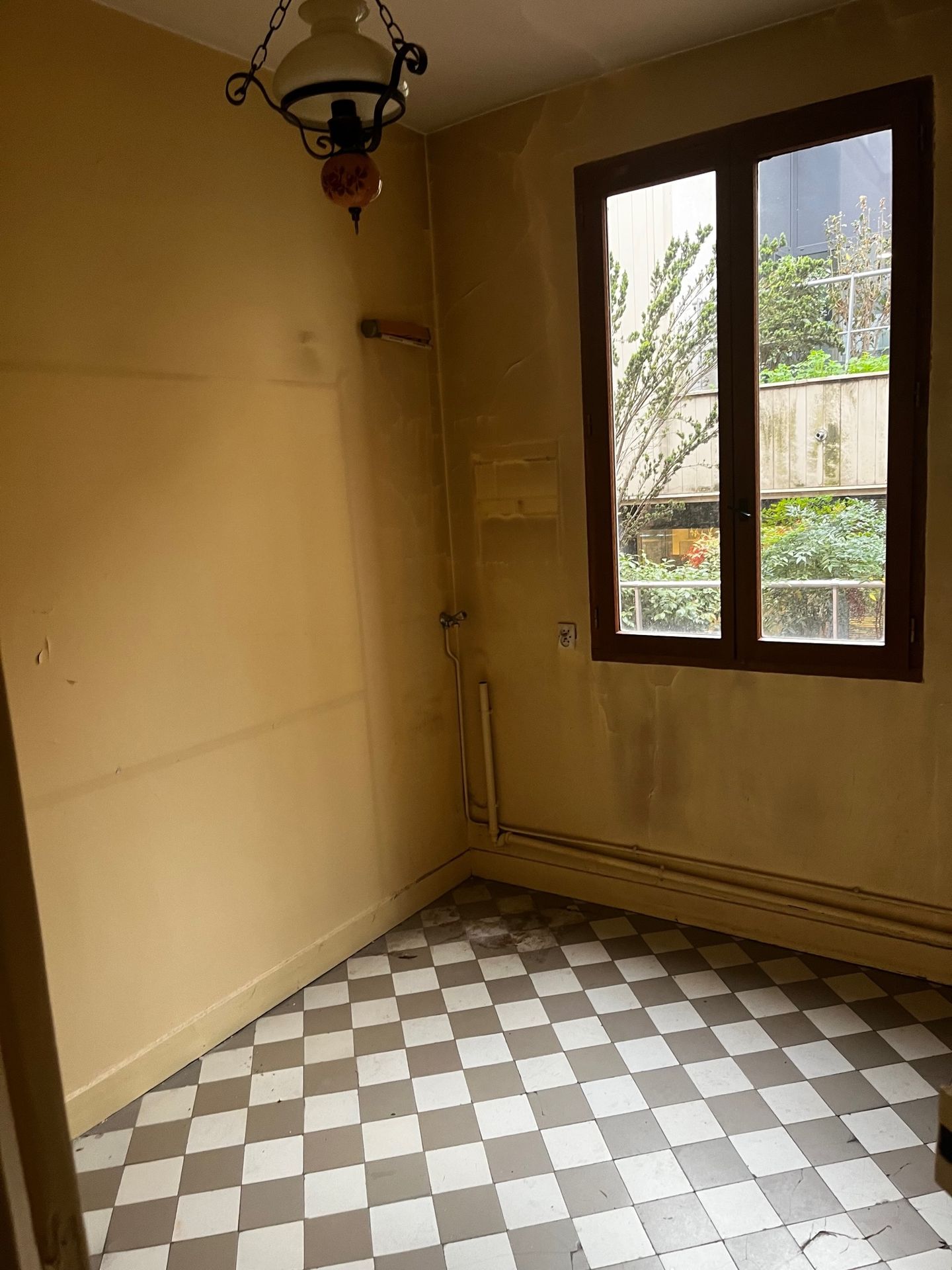 Détail d'une pièce technique en rénovation avec sol en carreaux de ciment d'époque.