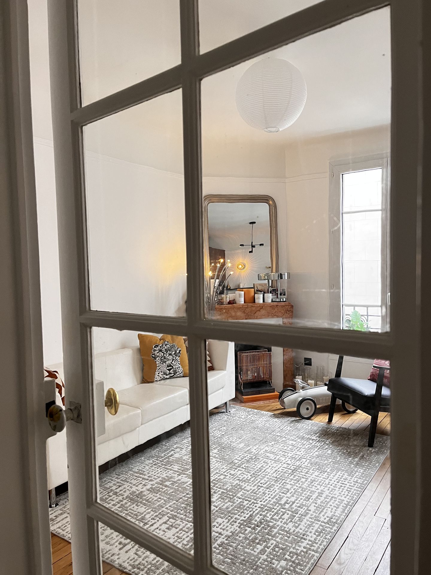 Zoom sur une verrière intérieure raffinée séparant le salon d'un espace bureau intimiste.