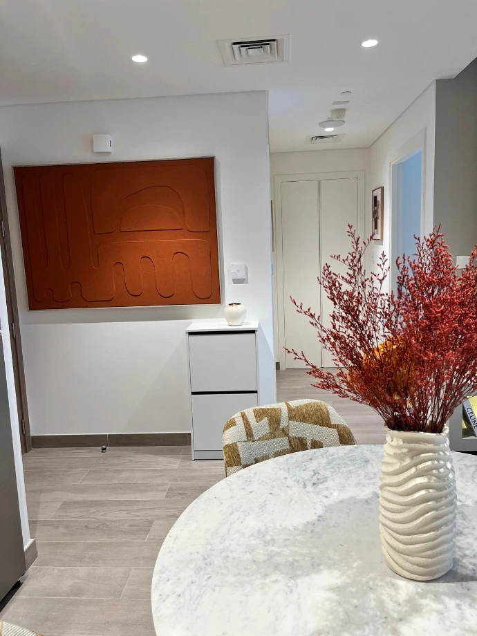 Curation artistique Nice Hunter Design : Tableau texturé terracotta sur mesure et mobilier d'entrée minimaliste blanc pour un intérieur de prestige.