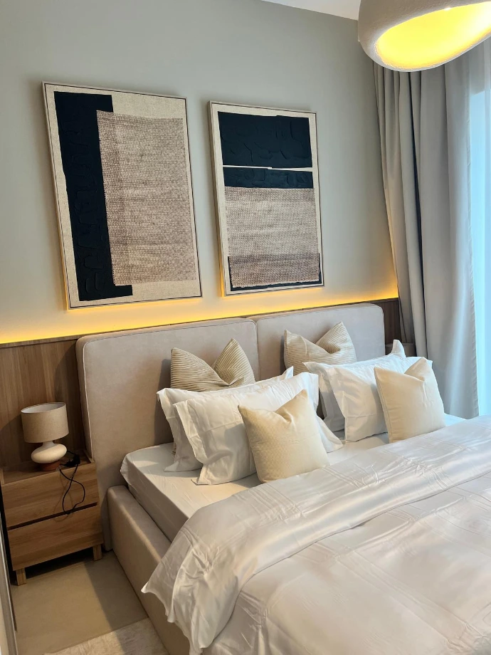 Design de chambre de luxe par Nice Hunter Design : Tête de lit sur mesure en bois et bouclé, éclairage LED indirect et tableaux d'art abstrait texturés.