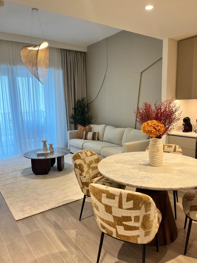 Architecture d'intérieur Nice Hunter Design : Salon contemporain avec table en marbre, chaises en tissu texturé ocre et suspension design sculpturale Illan.