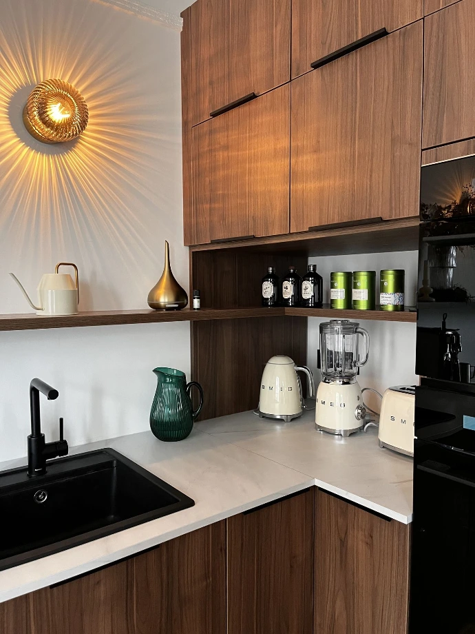 Cuisine sur mesure contemporaine mêlant bois chaleureux et plan de travail sombre élégant.